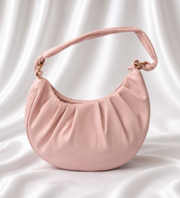 Blush pink crescent shoulder bag with soft pleated detailing and adjustable knotted strap by Eisela.