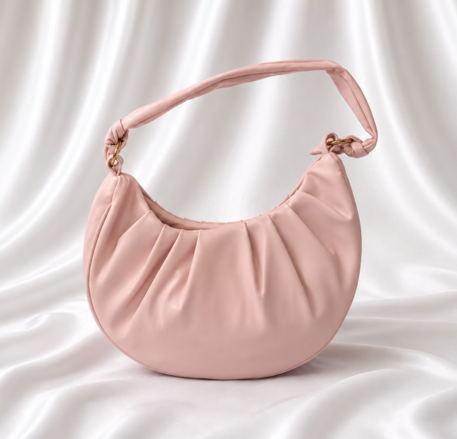 Blush pink crescent shoulder bag with soft pleated detailing and adjustable knotted strap by Eisela.