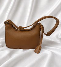 Eisela caramel brown pebbled crossbody bag with adjustable shoulder strap and gold-tone hardware.