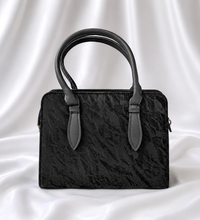 Black textured women's top handle handbag with structured design by Eisela.