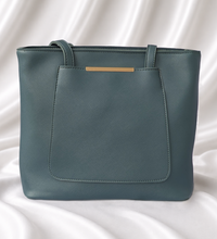 Sage green structured tote bag with front slip pocket, gold-tone accent, and dual shoulder handles by Eisela.