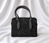 Black textured women's top handle handbag with structured design by Eisela.